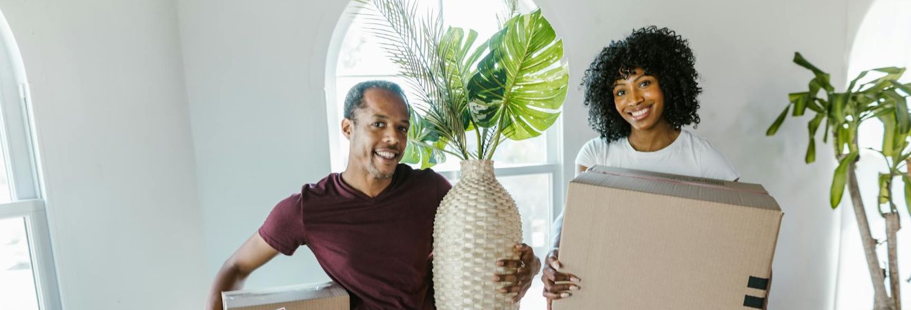 A couple holding moving boxes at home ready for movers Oakland Park FL