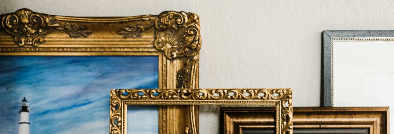Stacked paintings and frames ready for packing.