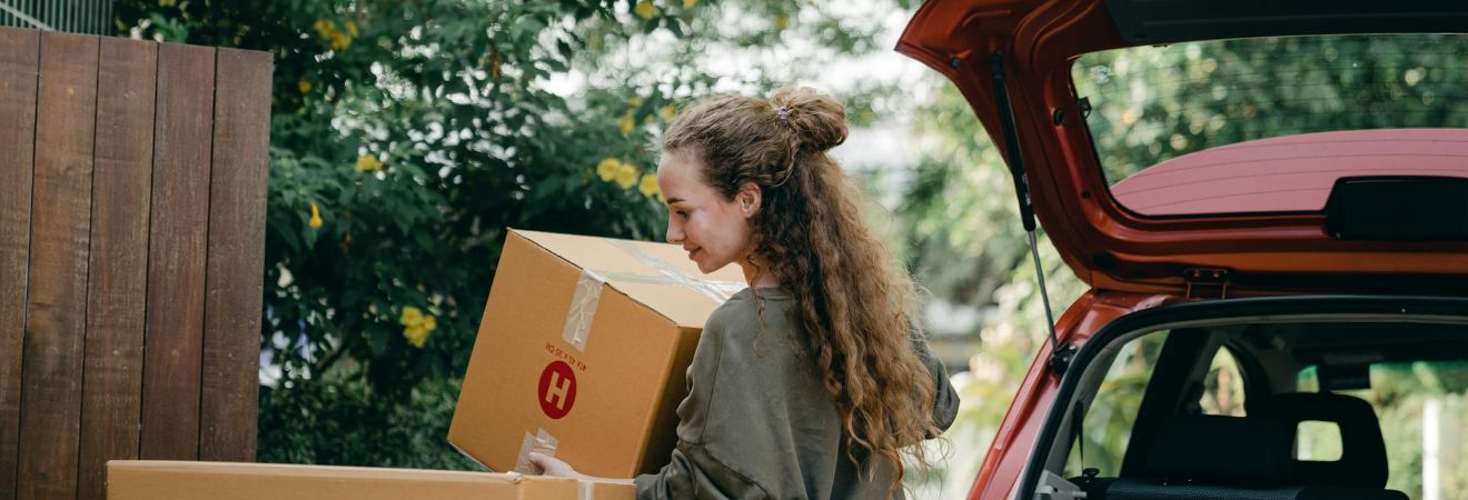 a woman carrying a box moved by moving companies hallandale beach
