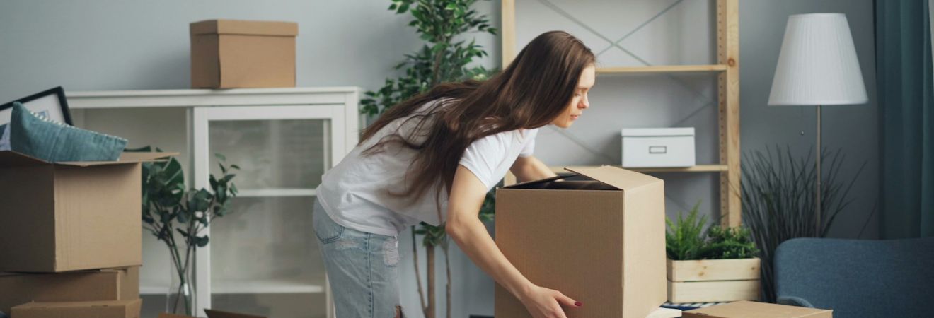 a woman carrying a cardboard box