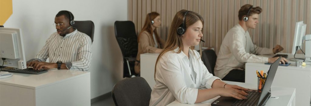 Four employees working in a call center during IT office relocation preparation in a modern office environment