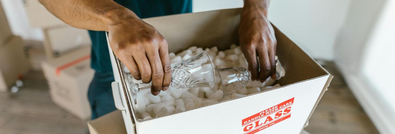 One of the fort lauderdale long distance movers packing fragile items in a box