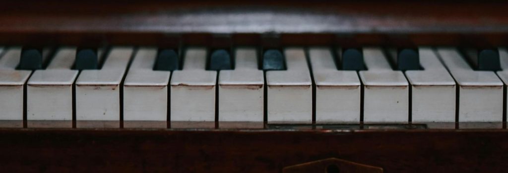 a close up view of a brown grand piano and its keys