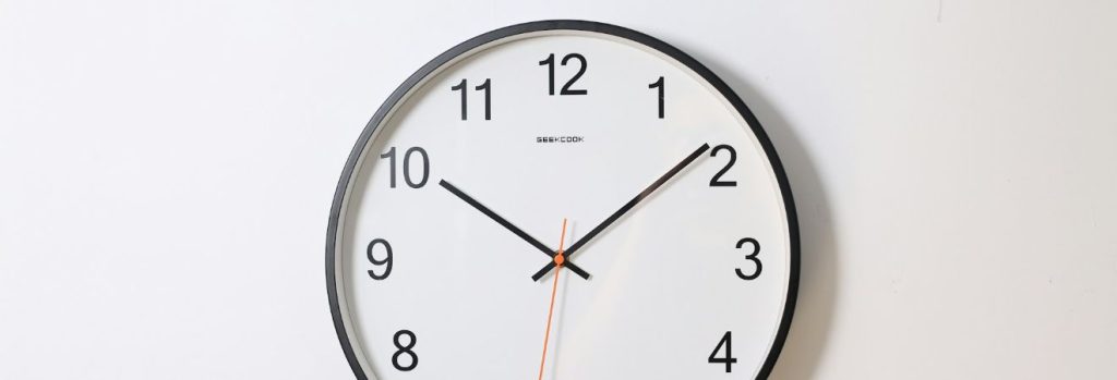 a wall clock hanging on a white wall