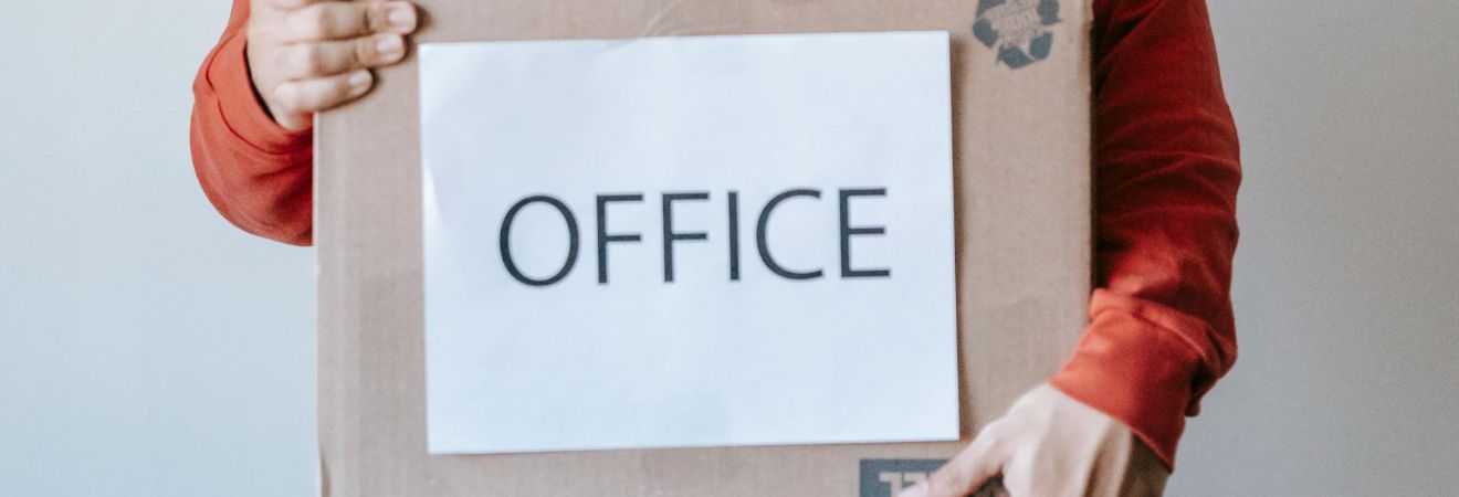 one of the fort lauderdale commercial movers carrying a cardboard box with office written on it