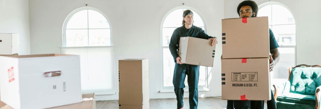 Two men carrying boxes during IT office relocation