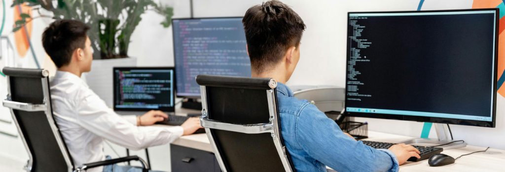 two people working on computers in a modern office setting
